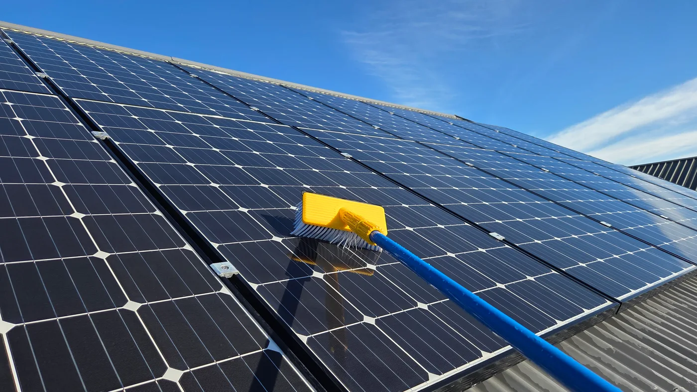 A soft cleaning brush on rooftop solar panels