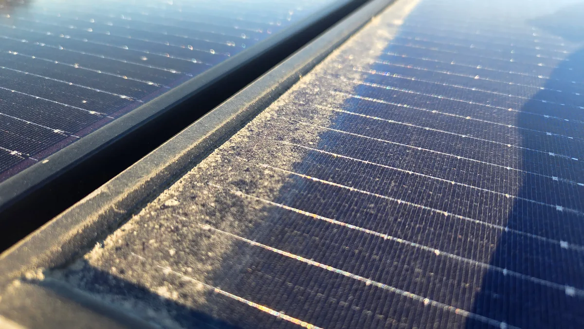 Close-up of visible dirt and buildup on solar panel glass
